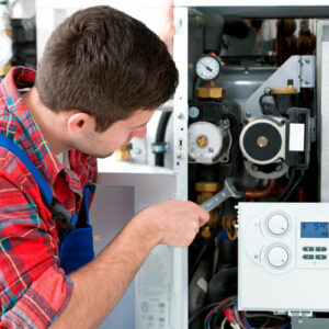 Technician servicing heating boiler